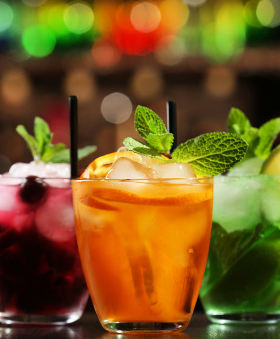 Three mixed drinks with cherry, orange and lime