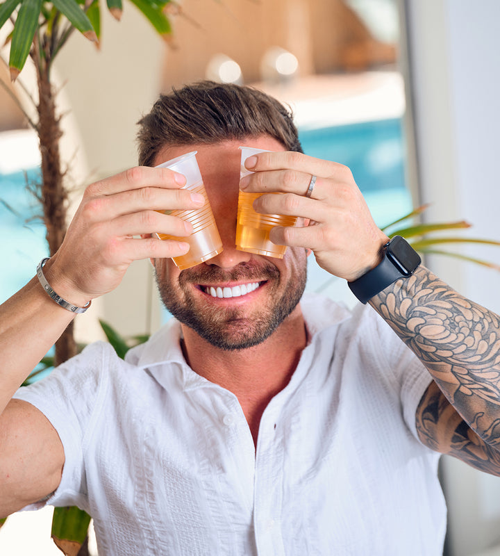 SIP Elixirs - Tattoo'd man enjoying two cocktails