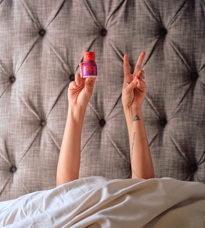 SIP Elixirs - Tattoo'd Woman in Bed with Sunset Punch - Sleep bottle, Peace Sign