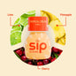 Sip Elixirs Tropical Crush Chill bottle surrounded by lime, pineapple, and cherry slices on a beige background